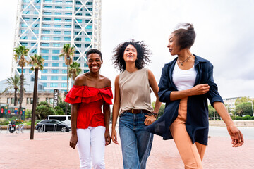 Three mixed race hispanic and black women bonding outdoors