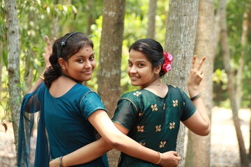Two Indian Asian collage girl students or friends posing for photograph