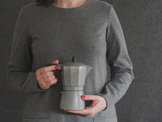 Close-up on a woman's hands holding a coffee maker