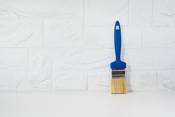 Repair brush with a blue handle on a light background. Copy space