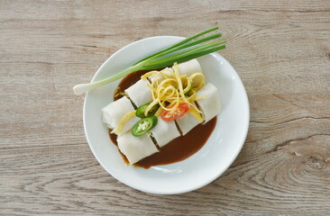 fresh Chinese spring roll made from flour wrapped tofu and pork with bean sprout dressing sweet red gravy sauce on plate  