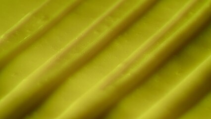 Beauty and skin care products advertisement creative concept. Close up shot of cream background. Face or body yellow cream fluid texture with strokes. Smooth moisturizer cream shot.