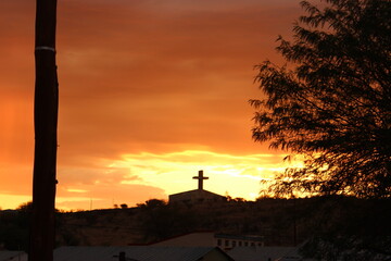 Sunset with a silouette of a cross on top of a church in Namibia