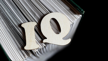 IQ. Intelligence. English wooden letters and book.