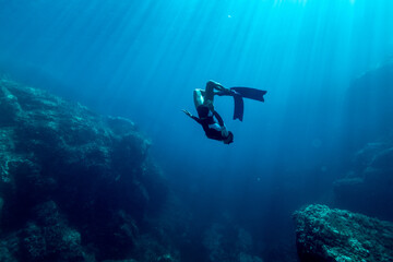 Girl with a sporty body practicing free diving in the crystal clear waters of Sardinia - 696401937