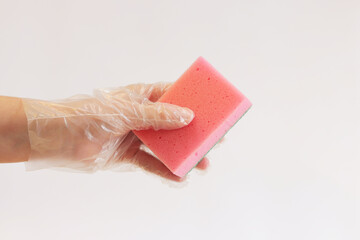 Cleaning the room, sponge in hand close-up. Female hand in a glove with a sponge for washing dishes...