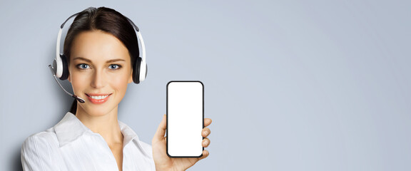 Customer support phone operator in headset hold showing smartphone cell phone mobile white blank...