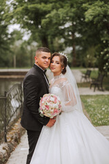 Wedding. Love and couple in garden for wedding. Celebrating the ceremony and commitment. Save the date. Trust. The groom embraces the bride. Tender kisses. Couple in love. Wedding portrait