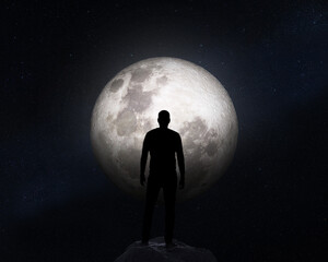 Silhouette of a man on background of the Moon. Elements of this image furnished by NASA.