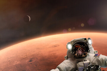 The astronaut takes a selfie against the backdrop of the planet Mars. Elements of this image courtesy of NASA.