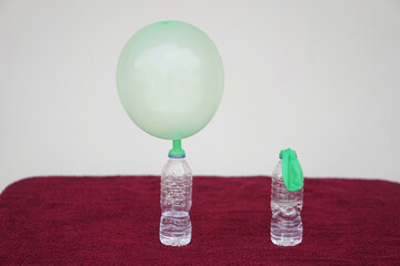 Science experiment , inflated balloons and flat balloon on top of transparent test bottles....
