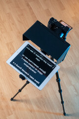 teleprompter for video. The reading text is reflected from the glass surface opposite the video camera lens