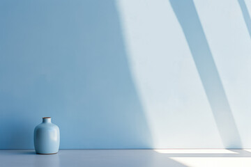 Blue vase against a light blue wall with soft shadows.