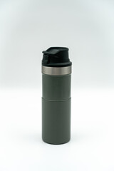 Green color metal durable thermos in front of white background close up