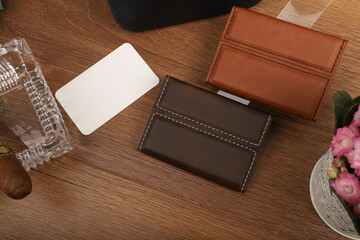 Colored leather business card holder, Genuine leather business card holder, concept shot, top view, different color, clamshell and stitched card holder. Wooden background.