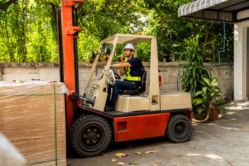 Man worker at forklift driver happy working in industry factory logistic ship. Man forklift driver in warehouse area. Forklift driver sitting in vehicle in warehouse..