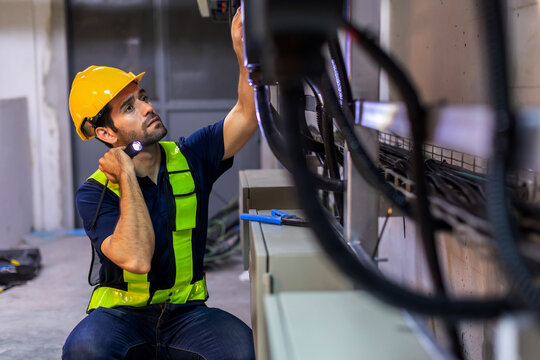 Electrical engineer working in control room. Electrical engineer man checking Power Distribution Cabinet in the control room