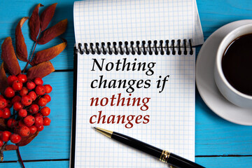 NOTHING CHANGES IF NOTHING CHANGES - words in a white notebook on a wooden blue background with a...