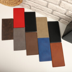 Fototapeta premium Colorful leather checkbook. Genuine leather checkbook, concept shot, top view, different color, clamshell and stitched checkbook