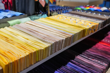Many different ties of multi colors yellow gradient assortment display at the exhibition showcase....