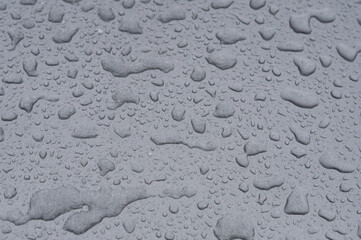 Creative background. Raindrops on a gray car