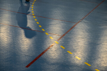 shadow of a player on the surface of a futsal field