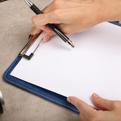 Colorful leather clipboard. Genuine leather clipboard, concept shot, top view, different color, woman about to write a note on empty blank with a pen.