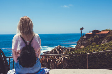 Young Woman Relaxing at Summer Sky Outdoor in a front of Pacific Ocean. Freedom style. Laguna Beach. California. USA