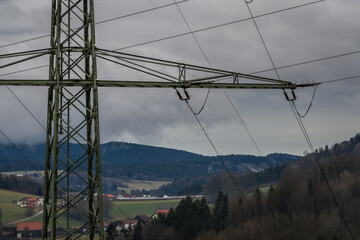 Hochspannungsmast im ländlicher Landschaft mit dunkeln Wolken vor einem Sturm, Deutschland