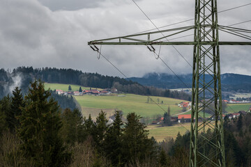 Hochspannungsmast im ländlicher Landschaft mit dunkeln Wolken vor einem Sturm, Deutschland