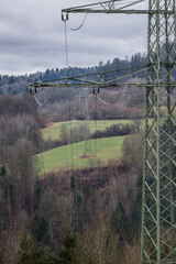 Hochspannungsmast im ländlicher Landschaft mit dunkeln Wolken vor einem Sturm, Deutschland