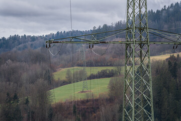 Hochspannungsmast im ländlicher Landschaft mit dunkeln Wolken vor einem Sturm, Deutschland