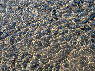 Wellenmuster auf dem Boden eines Bachs in Grönland. Auch als abstrakter Hintergrund geeignet.