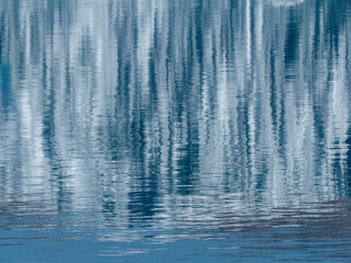 Wasseroberfläche mit Refleionen von Eisbergen mit interessanten Mustern in einem Fjord in Grönland