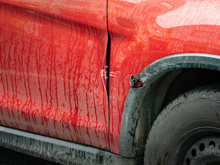 Car body damage after a collision at the parking lot. Scratches and warped sheet metal at the...