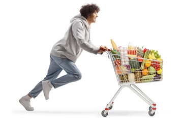 Young man running with food in a shopping cart