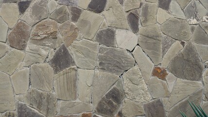 granite slabs in the exterior decor of a building, a pattern of marble pieces on a facade or fence, the use of solid natural stone in decoration and construction