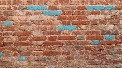 old red brick wall with splashes of blue blocks as a background texture for design, textured brickwork backdrop with empty copy space, graphic resource of the relief surface