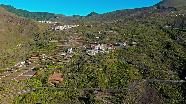 Drone view of Tamaimo village over serpentine streets through the Teno mountains. Aerial view of colourful houses in Tamaimo tropical in 4K.