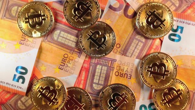 Bitcoin Coins on the 50 Euro Banknotes - Top View. Euro Money Cash and Cryptocurrency. A Lot of Fifty Euro Bills. Finances, Exchange, Blockchain and Electronic Money Concept - Slow Rotation Left