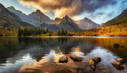 Wall murals Tatra Mountains awesome nature landscape beautiful scene with high tatra mountain peaks stones in mountain lake calm lake water reflection colorful sunset sky amazing nature background autumn adventure hiking