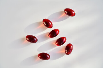 Red krill oil pills on white background