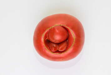Red tomato with bumps in the form of hemorrhoids.