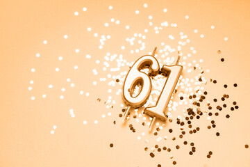 61 years celebration festive background made with golden candles in the form of number Sixty-one lying on sparkles. Universal holiday banner with copy space.