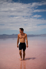 Man walking in shallow Pink Salt Lake in Utah near Salt Lake City.  Located in the Southwest of the...