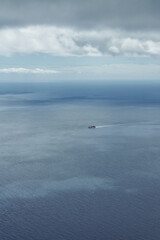 a cargo ship on the Atlantic, nothing but water and sky around the ship, minimalistic
