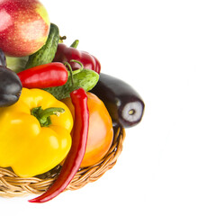 Fruits and vegetables in a wicker basket isolated on a white. Free space for text.