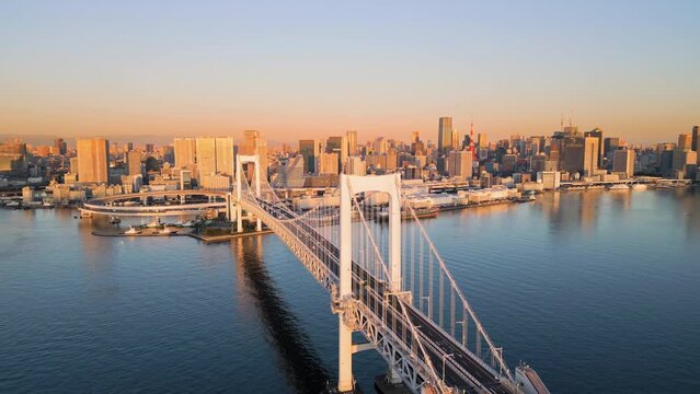 tokyo city skyline aerial view drone of rainbow bridge at sunrise dawn,downtown waterfront in the background