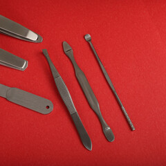 Manicure set kit in Colorful leather case. Concept shot, top view, different colors Manicure set. Special background Manicure set view. Red background.