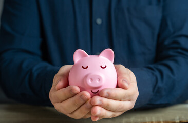 A calmly sleeping piggy bank in the hands. Trust fund. A reliable way to store savings and passive income. Savings and deposit banking. Wealth and prosperity. Successful investments and deposits.